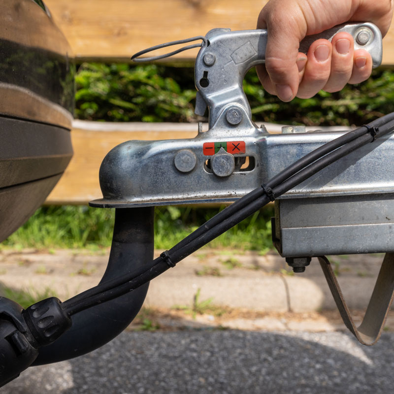 man latching trailer to hitch